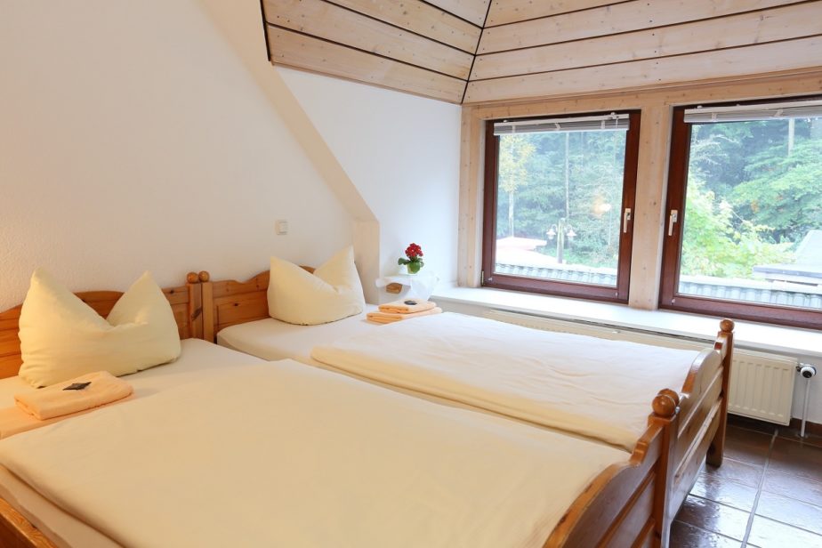Helles, gemütliches Doppelzimmer mit Doppelbett vor einem Fenster mit schönen Ausblick